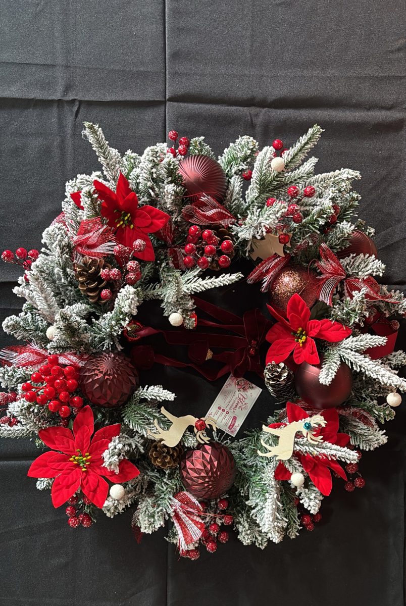 Frosted pine wreath with red poinsettias, berries, burgundy baubles and wooden reindeer
